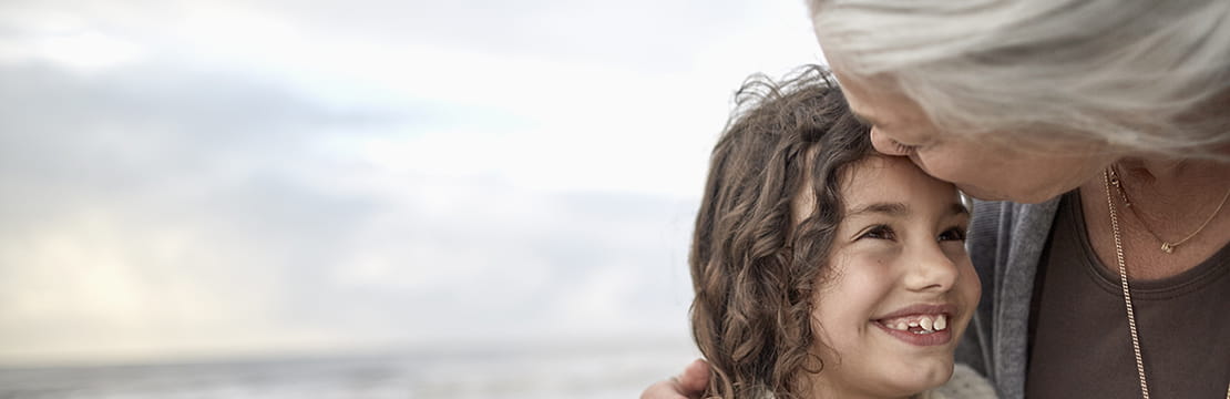Grandmother and happy granddaughter on the beach