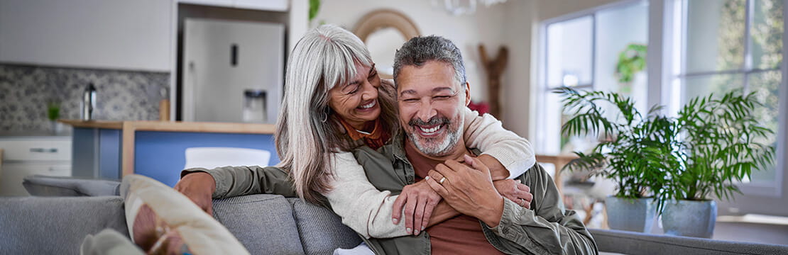 retired multiethnic couple hugging and laughing